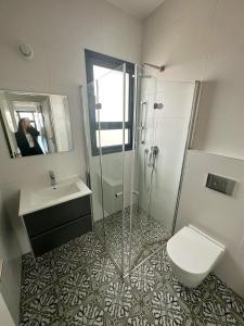 y baño con ducha, aseo y lavamanos. en O&O Group -Stellar Luxury 4BR APT en Bat Yam