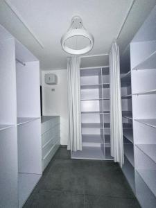 vestidor con armarios blancos y luz en O&O Group -Stellar Luxury 4BR APT en Bat Yam