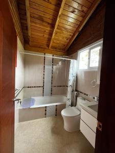 a bathroom with a toilet and a tub and a sink at Cabañas Tecla María in Otavalo