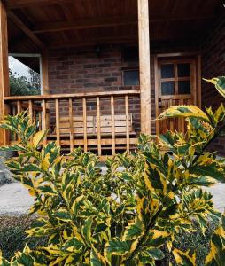 una veranda di una casa con panchina in legno di Cabañas Tecla María a Otavalo