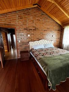 a bedroom with a brick wall and a bed at Cabañas Tecla María in Otavalo