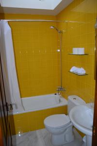 ein gelb gefliestes Badezimmer mit Toilette und Waschbecken in der Unterkunft Casa Rural San Ignacio: una casa indiana en Soria in Valdeavellano de Tera