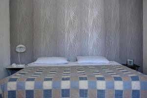 a bedroom with a bed with a blue and white blanket at Studio apartment Kasalo in Kaštela