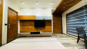 a living room with a flat screen tv and a door at Nisarg’s stays in Ahmedabad