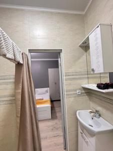 baño con lavabo y habitación con cama en Мини-гостиница Береке en Aktobe