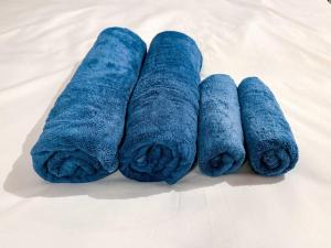 3 rollos de toallas azules en una cama en R 新大阪 FUJI サウナ付きの５LDK　3つのお風呂でグループで楽しめます。, en Osaka 52 fotos más