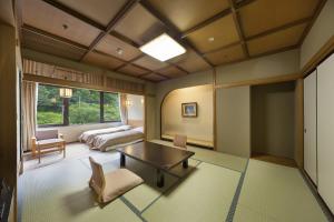 水上町聚乐水上日式旅馆的一间卧室配有一张床、一张桌子和一张沙发