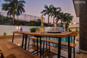 a wooden table with a bottle of wine on a patio at EKO STAY- Paramount Villa in Lonavala