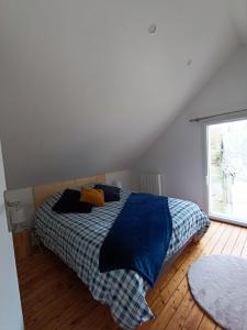 1 dormitorio con cama con sábanas azules y ventana en Gîte à côté de " la Java bleue" en bord de rivière, en Amanlis