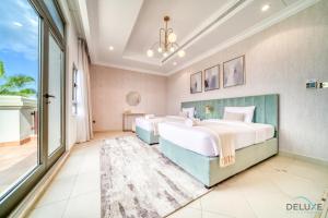 dwa łóżka w sypialni z dużym oknem w obiekcie Seaside 5BR Villa with Assistant's Room and Beach Access on Palm Jumeirah by Deluxe Holiday Homes w Dubaju