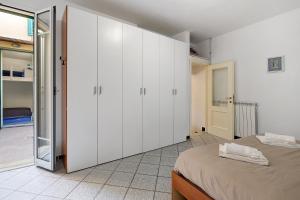 een slaapkamer met witte kasten en een bed bij Incantevole casa del Borgo in Finale Ligure