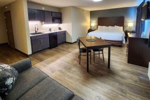 a hotel room with a bed and a table and a kitchen at Econo Lodge in Ortonville