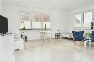CO01-HI Apartment für Facharbeiter in Coburg في كوبورغ: غرفة معيشة بيضاء مع طاولة وكراسي