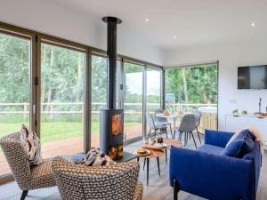 - un salon avec un canapé bleu et une cheminée dans l'établissement 2 Bed in East Bergholt 82398, à East Bergholt