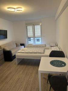 Habitación pequeña con 2 camas y sofá en Neckar-Apart, en Heilbronn