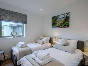 um quarto com 2 camas e uma janela em 2 Bed in East Bergholt 82398 em East Bergholt