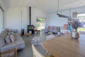 sala de estar con mesa y sofá en A Factoria Beach House by Prishomes, en Hío