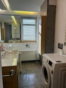 a bathroom with a sink and a washing machine at Penthouse apartament na wyłączność - taras z jacuzzi - Stadion Narodowy - Saska Kępa 8-12 osób in Warsaw