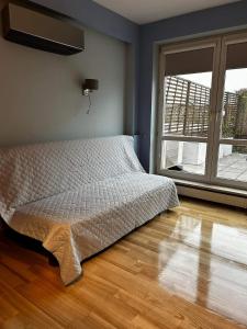 a bedroom with a bed and a large window at Penthouse apartament na wyłączność - taras z jacuzzi - Stadion Narodowy - Saska Kępa 8-12 osób in Warsaw