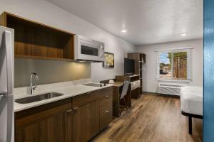 a kitchen with a sink and a microwave at WoodSpring Suites Yorktown Newport News in Newport News