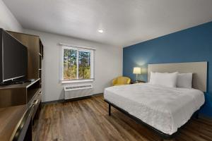 a bedroom with a bed and a blue wall at WoodSpring Suites Yorktown Newport News in Newport News
