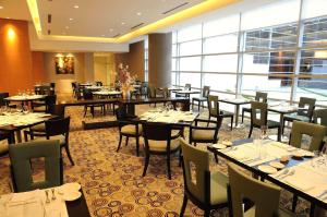 a restaurant with tables and chairs and a large window at Hilton Mendoza in Mendoza