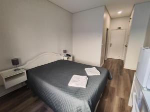 ein Schlafzimmer mit einem Bett mit zwei Handtüchern darauf in der Unterkunft Residencial Centro Comercial Avenida Bragashopping in Braga