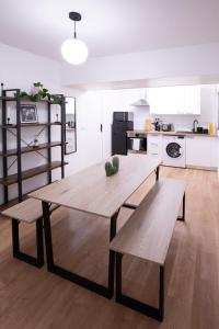 une cuisine avec une table en bois et deux bancs dans l'établissement Joli appartement Parc de la Villette - 4P, à Paris
