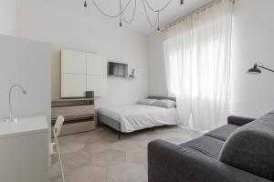 - un salon avec un canapé et un lit dans l'établissement Appartamento Turati 52, à Bologne