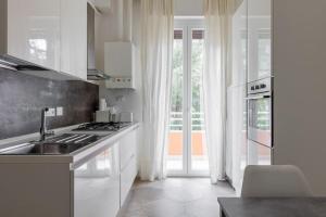 - une cuisine blanche avec évier et cuisinière dans l'établissement Appartamento Turati 52, à Bologne