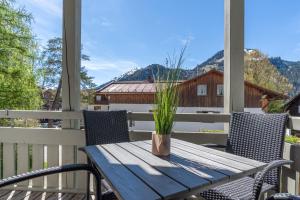 a wooden table with a potted plant on a porch at Edelweiß in Bad Hindelang