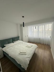 a bedroom with a large bed with two towels on it at GreenRooms Rare Apartment Central of Suceava in Suceava