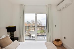 a bedroom with a bed and a sliding glass door at The Wembley Park Sanctuary - Stunning 2BDR Flat with Balcony in London