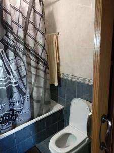 a bathroom with a toilet and a shower curtain at Ático de 60 m2 en urbanización privada in Noja