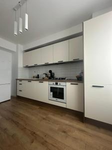 a kitchen with white cabinets and a stove at GreenRooms Rare Apartment Central of Suceava in Suceava
