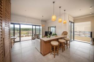 an open kitchen with a counter and stools at Luxury Villa w Pool Balcony in Regnum Golf Club in Çamlık