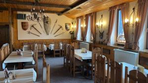 a restaurant with tables and chairs and a clock on the wall at Hotel Bozi Dar - Excalibur in Boží Dar