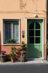 una porta verde su un edificio con due finestre e piante di B&B Casanonni Borgo Angeli a Mantova