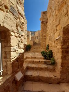a stone alley with stairs in an old building at Fig tree hotel in Dana