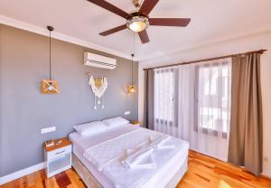a bedroom with a bed and a ceiling fan at Luna Kaş in Kaş