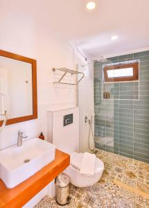 a bathroom with a sink and a toilet and a shower at Luna Kaş in Kaş