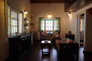 sala de estar con sofá y mesa en Whispering Waters - Wild Rose Cottage, en Kodaikanal