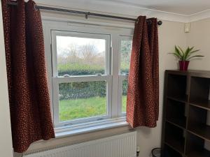uma janela com cortinas numa sala de estar em Riverview em Colchester