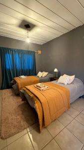 2 camas en una habitación con cortinas azules en Room en El Chaltén
