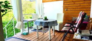 een veranda met een tafel en stoelen op een balkon bij Ferienwohnungen - Panoramablick in Bayreuth