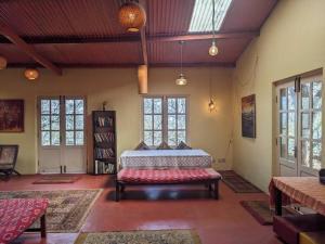 1 dormitorio con 1 cama en una habitación con ventanas en Whispering Waters - Wild Rose Cottage, en Kodaikanal