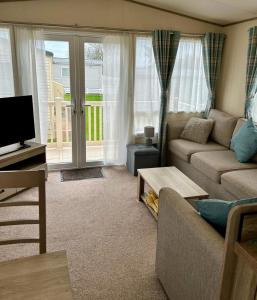 a living room with a couch and a tv at Beautiful Static Caravan Hoburne Devon Bay in Paignton