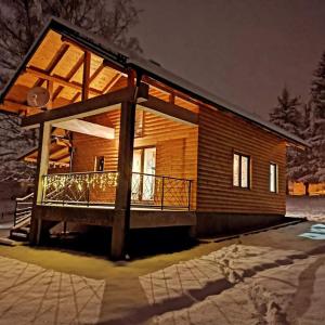 a small wooden house with a large deck at Brvnara Vidra in Pale