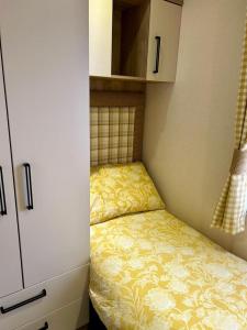 ein kleines Schlafzimmer mit einem Bett und einem Schrank in der Unterkunft Beautiful Static Caravan Hoburne Devon Bay in Paignton