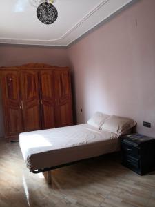 um quarto com uma cama e um armário de madeira em Family house 2 bedrooms, 2 sdb, near Center of Nador & Airport em Selouane